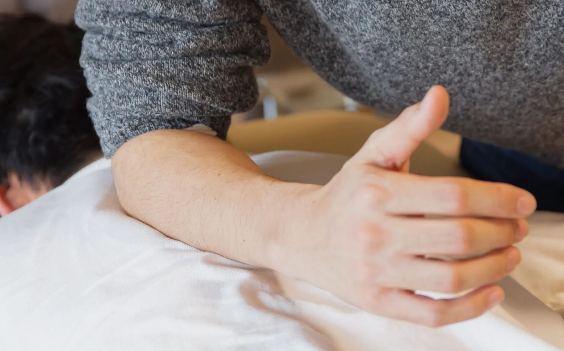 A chiropractor performing a gentle spinal adjustment on a patient