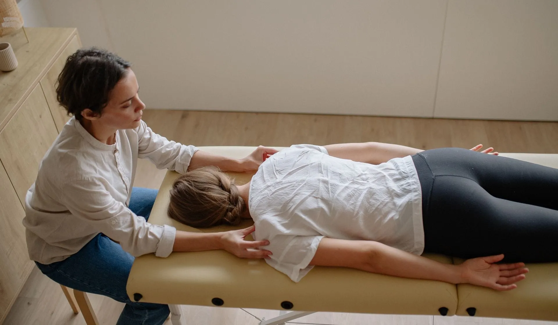 A patient lying comfortably on a treatment table receiving gentle spinal care
