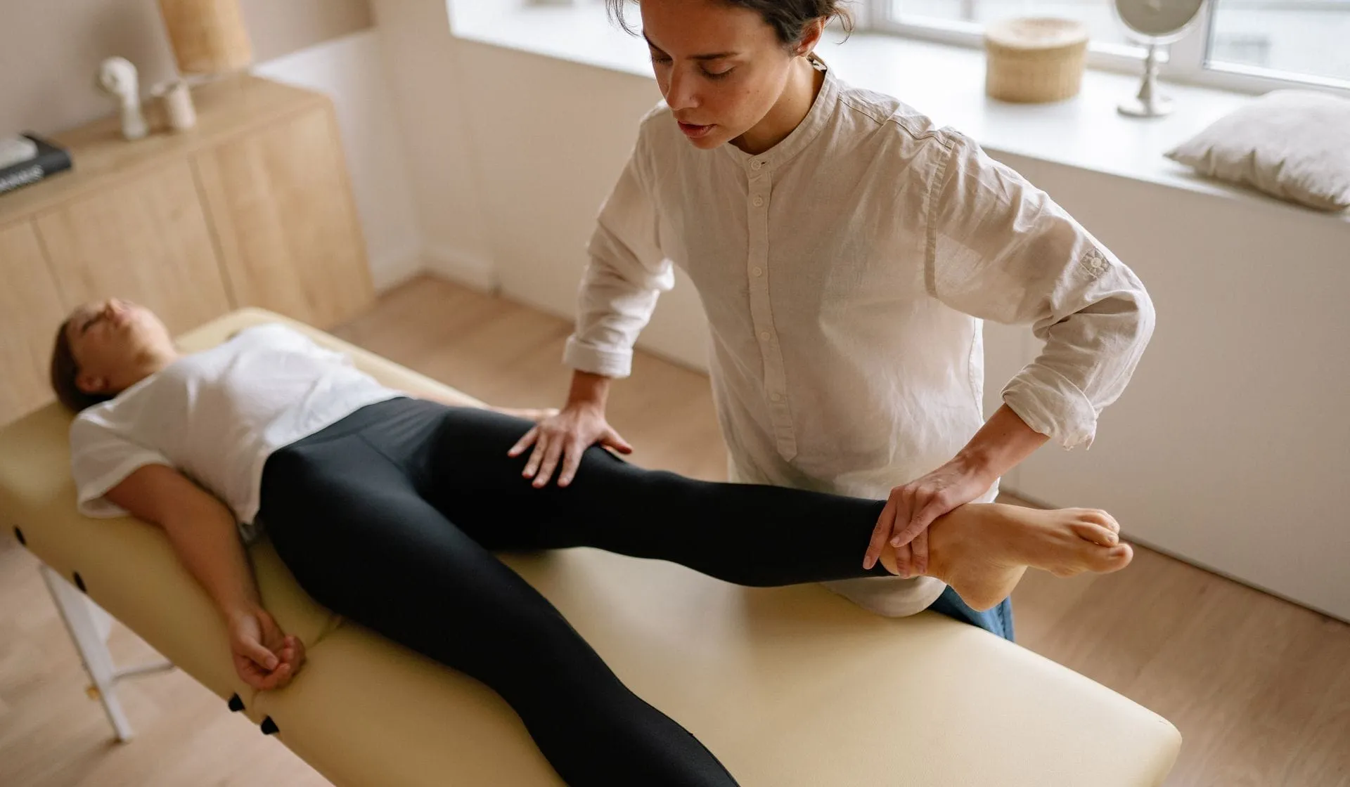 A physiotherapist treating a patient’s leg during a therapy session